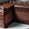Close-up of black velvet cake with dark cocoa crumb and creamy white frosting