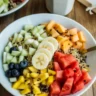 Colorful quinoa breakfast bowl topped with fresh fruits and nuts.
