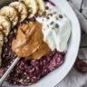 Bowl of steel cut oatmeal topped with fresh blueberries and a sprinkle of cinnamon.
