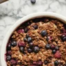 Berry quinoa fruit crumble cups topped with a crunchy quinoa mixture.