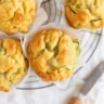 Zucchini and cheese breakfast muffins fresh out of the oven, garnished and ready to eat.