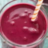 Coconut milk and berry smoothie in a glass with fresh berries on top