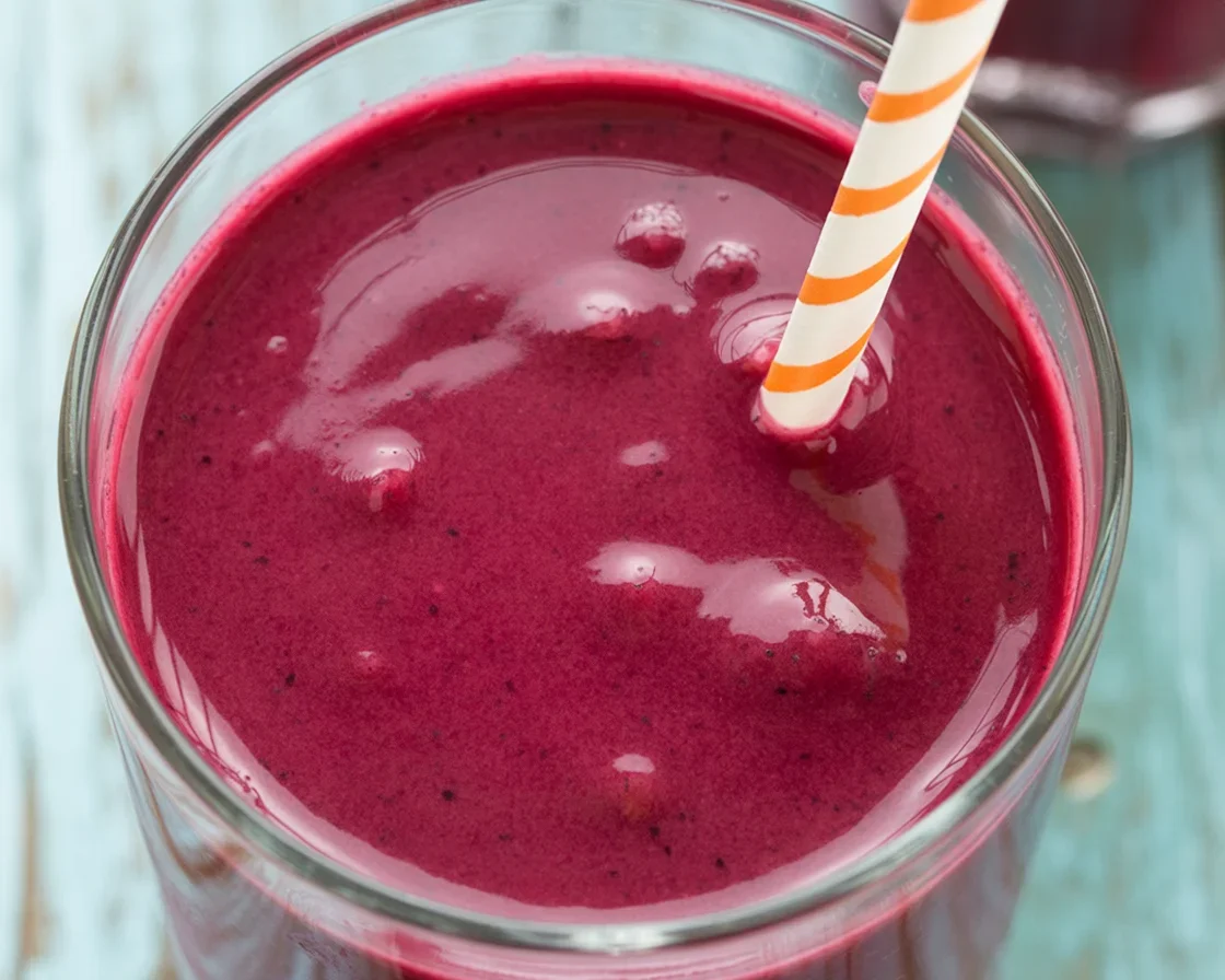 Coconut milk and berry smoothie in a glass with fresh berries on top