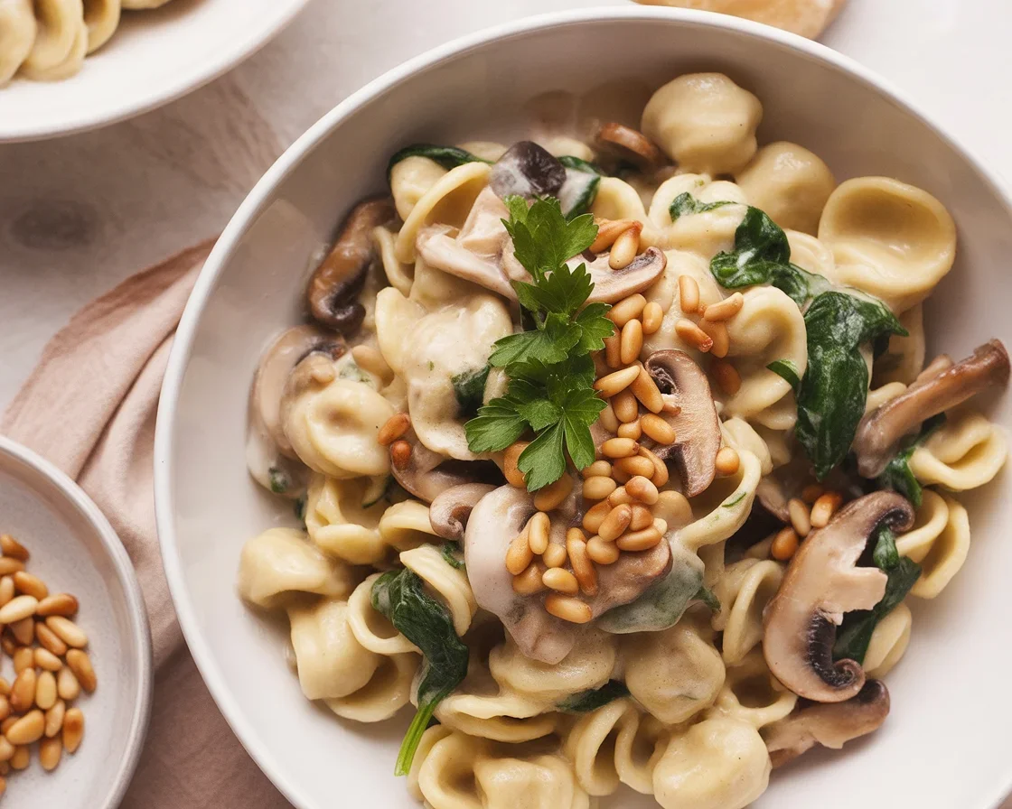 Creamy mushroom spinach gluten-free pasta served in a bowl with fresh herbs