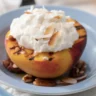 Grilled peaches served in a bowl with cottage cheese, garnished with fresh fruit.