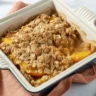 Delicious peach crisp with oat topping served warm, ideal for dessert lovers