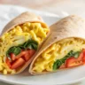 Spinach feta breakfast wrap filled with eggs, fresh spinach, and feta cheese, ideal for meal prep.