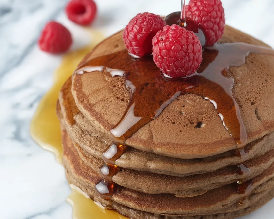 Delicious chocolate peanut butter protein pancakes topped with banana slices and syrup