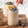 Bowl of cinnamon raisin overnight oats topped with fresh raisins and cinnamon