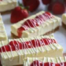 Delicious strawberry cheesecake bars with fresh strawberries on a graham cracker crust.
