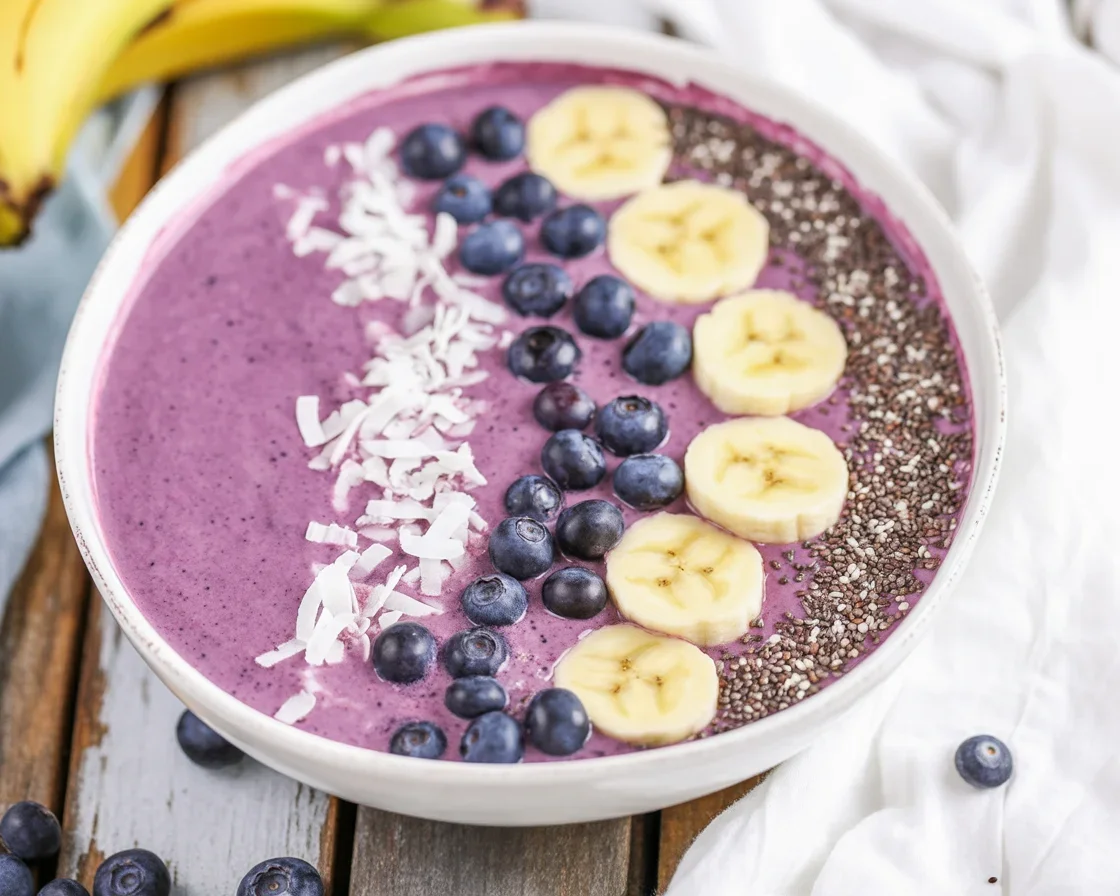 Blueberry protein smoothie bowl topped with fresh fruit and chia seeds.
