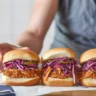 BBQ pulled jackfruit sliders served with avocado slaw on a wooden board
