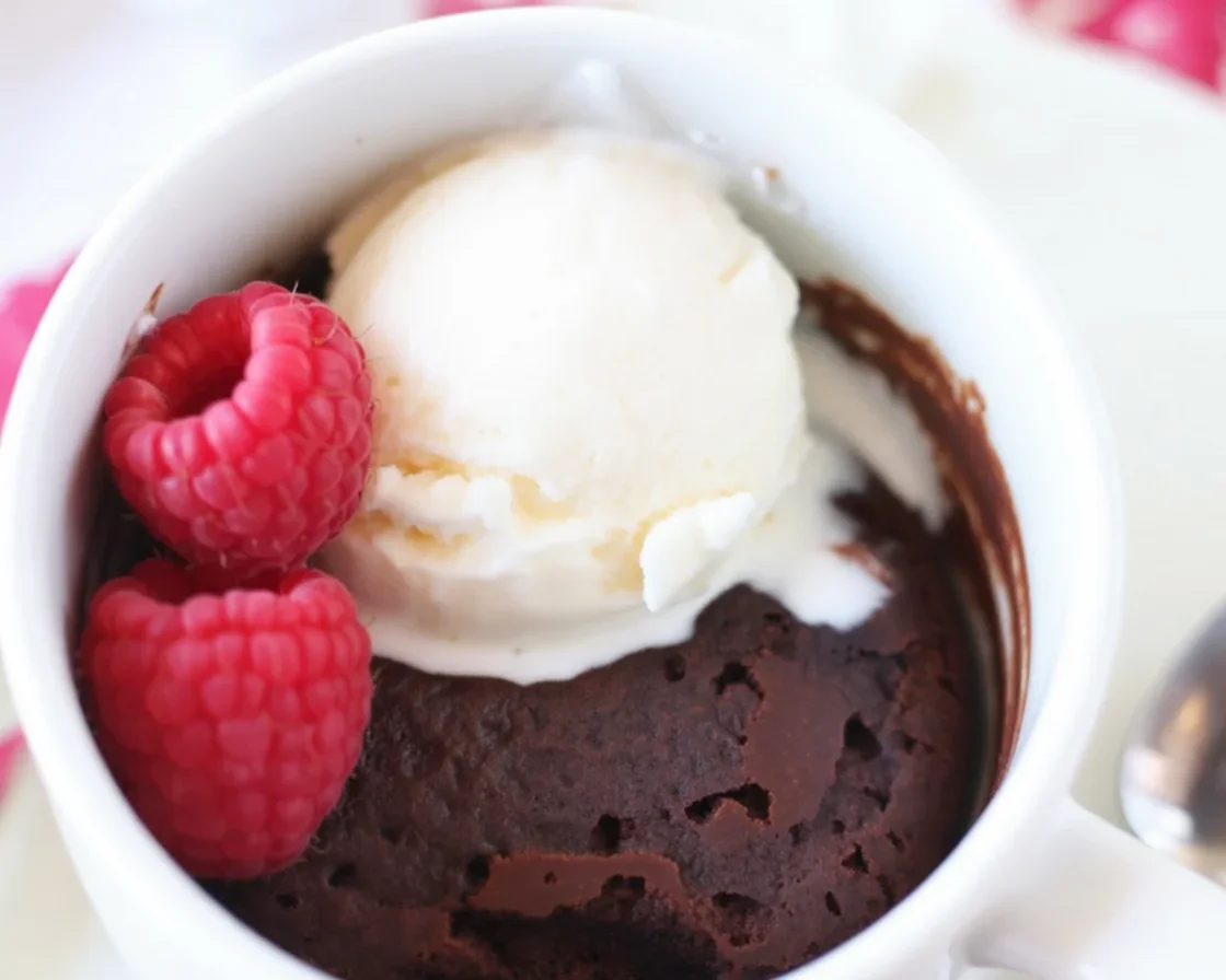 Easy mug brownie in a mug recipe with chocolate chips and ice cream on top